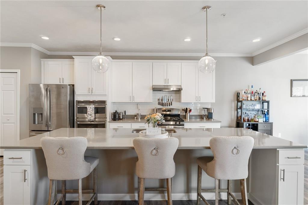 380 Trinity Way Wexford, PA 15090 - Photo 12 of 29 a kitchen with stainless steel appliances kitchen island granite countertop a table chairs refrigerator and microwave