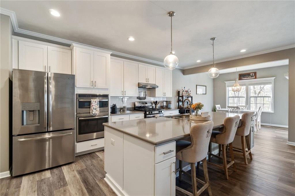 380 Trinity Way Wexford, PA 15090 - Photo 8 of 29 a kitchen with stainless steel appliances granite countertop a refrigerator a sink a stove a dining table and chairs