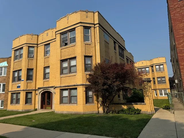 a front view of a residential apartment building with a yard