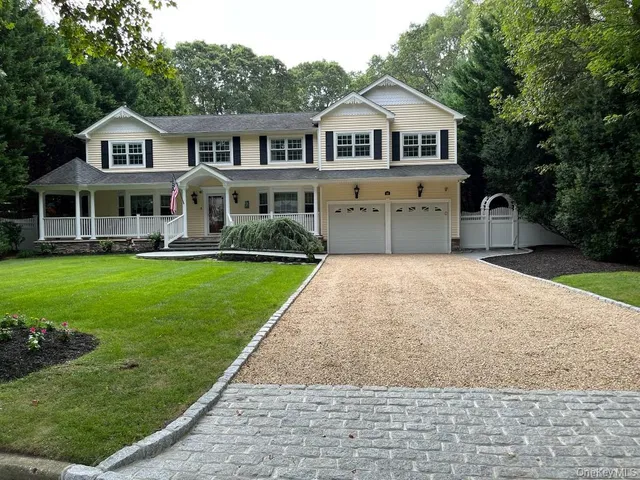 a front view of a house with a yard and trees