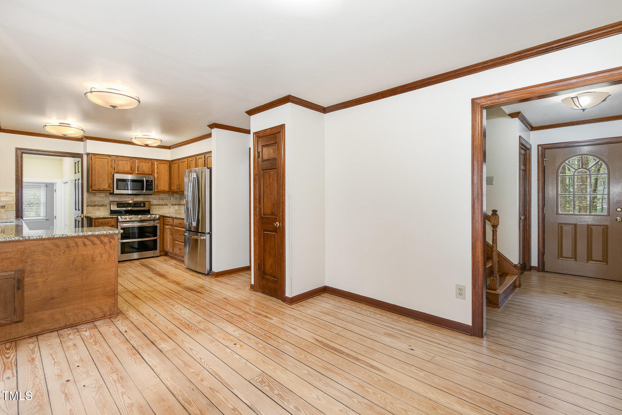 7212 Rabbit Run Wake Forest, NC 27587 - Photo 11 of 32 a kitchen with stainless steel appliances wooden floor and large windows