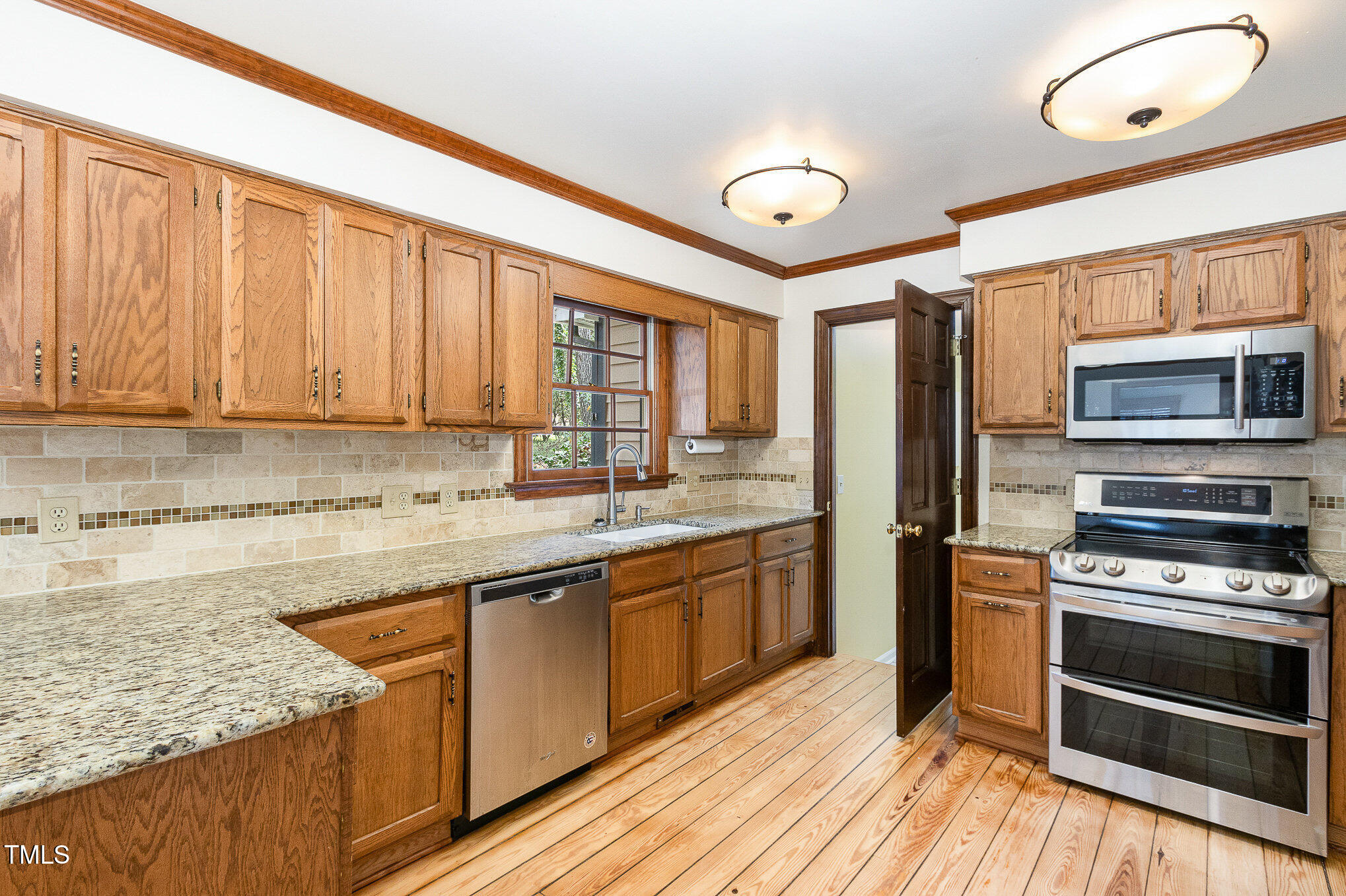 7212 Rabbit Run Wake Forest, NC 27587 - Photo 14 of 32 a kitchen with stainless steel appliances granite countertop a stove sink and cabinets