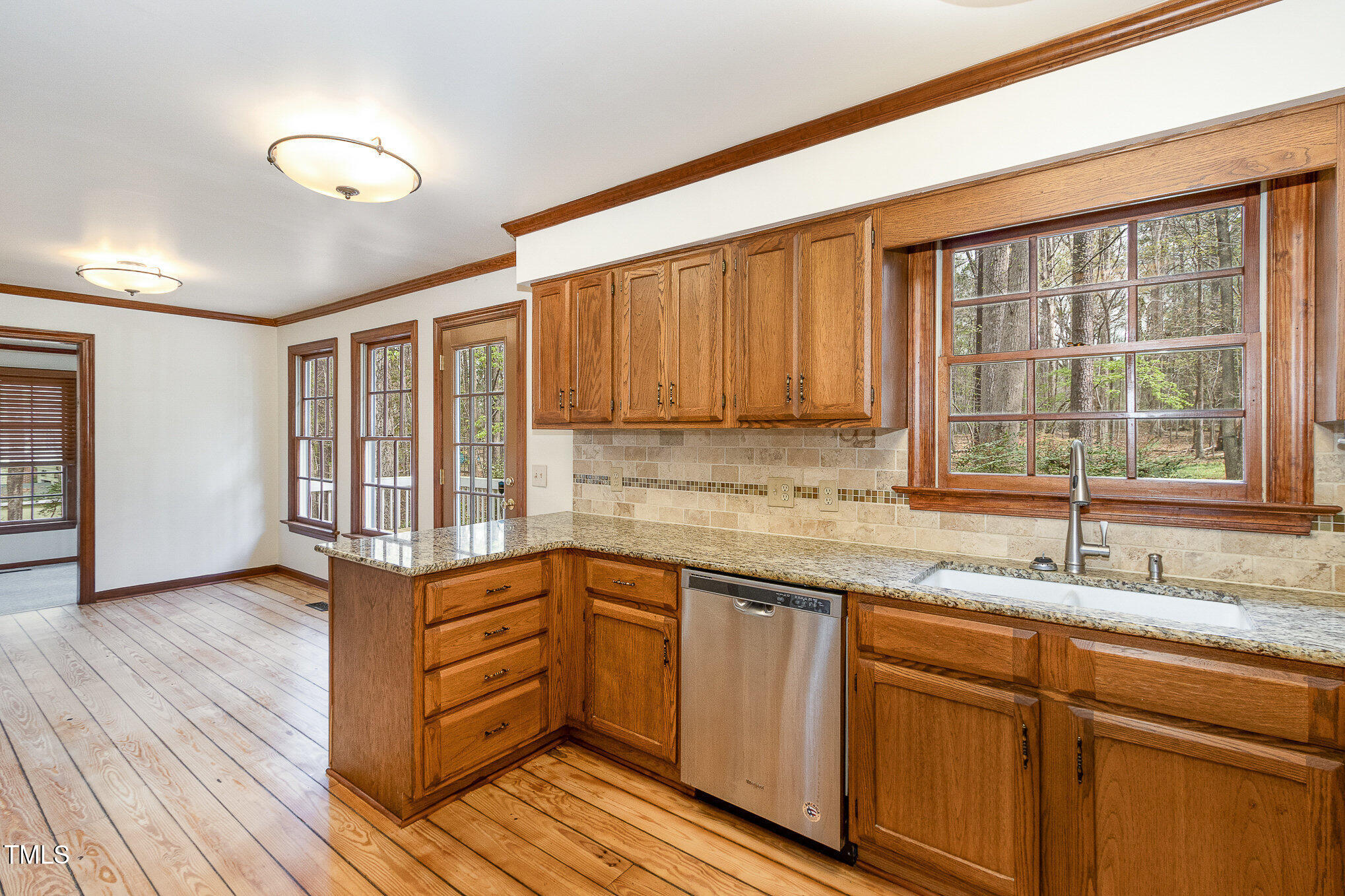 7212 Rabbit Run Wake Forest, NC 27587 - Photo 16 of 32 a kitchen with granite countertop wooden cabinets a sink and dishwasher with wooden floor