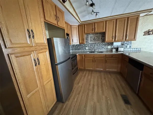 a kitchen with stainless steel appliances granite countertop a sink stove and cabinets