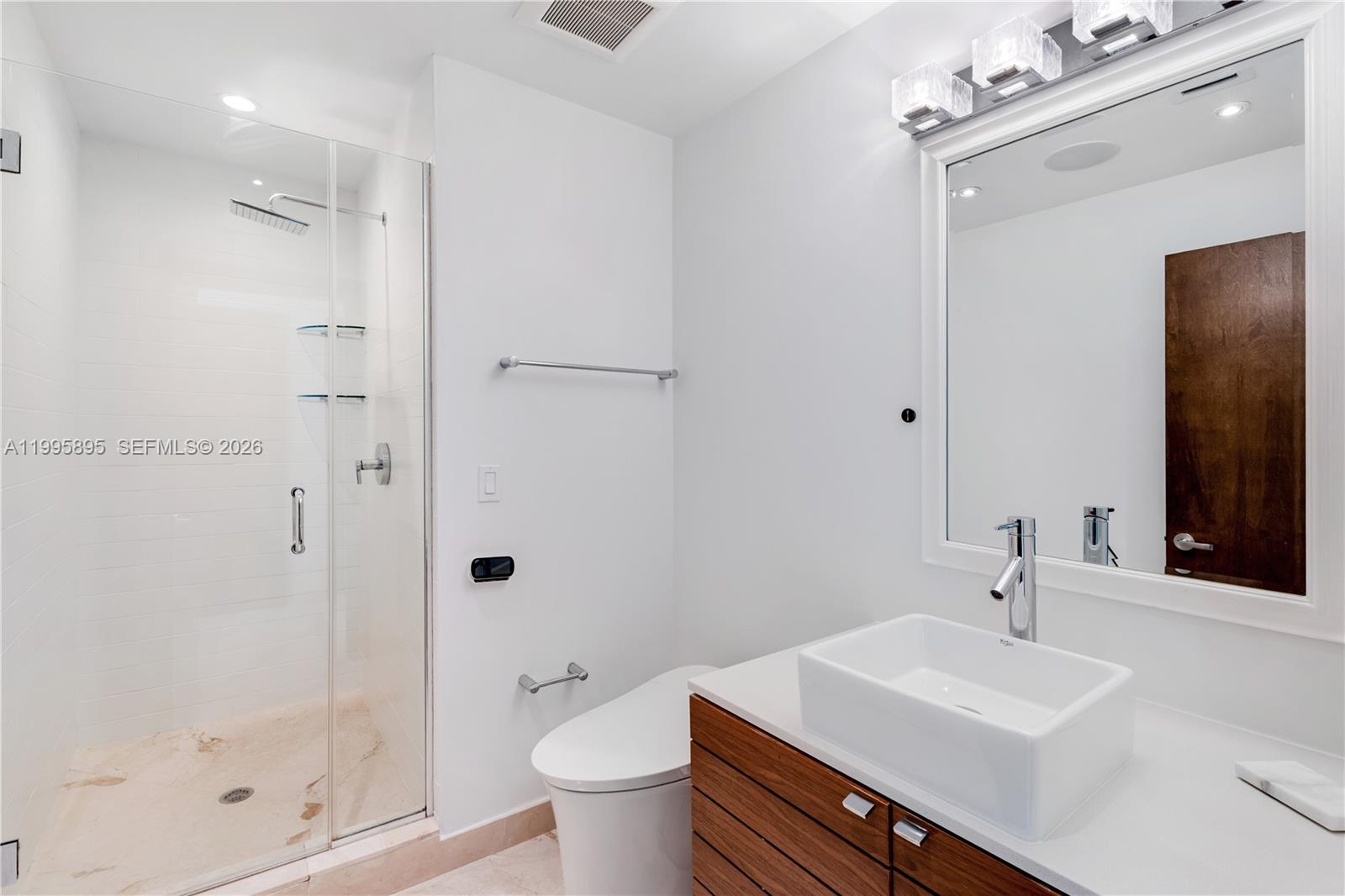 548 Fernwood Road, Unit 548 Key Biscayne, FL 33149 - Photo 26 of 50 a bathroom with a sink toilet a mirror and shower