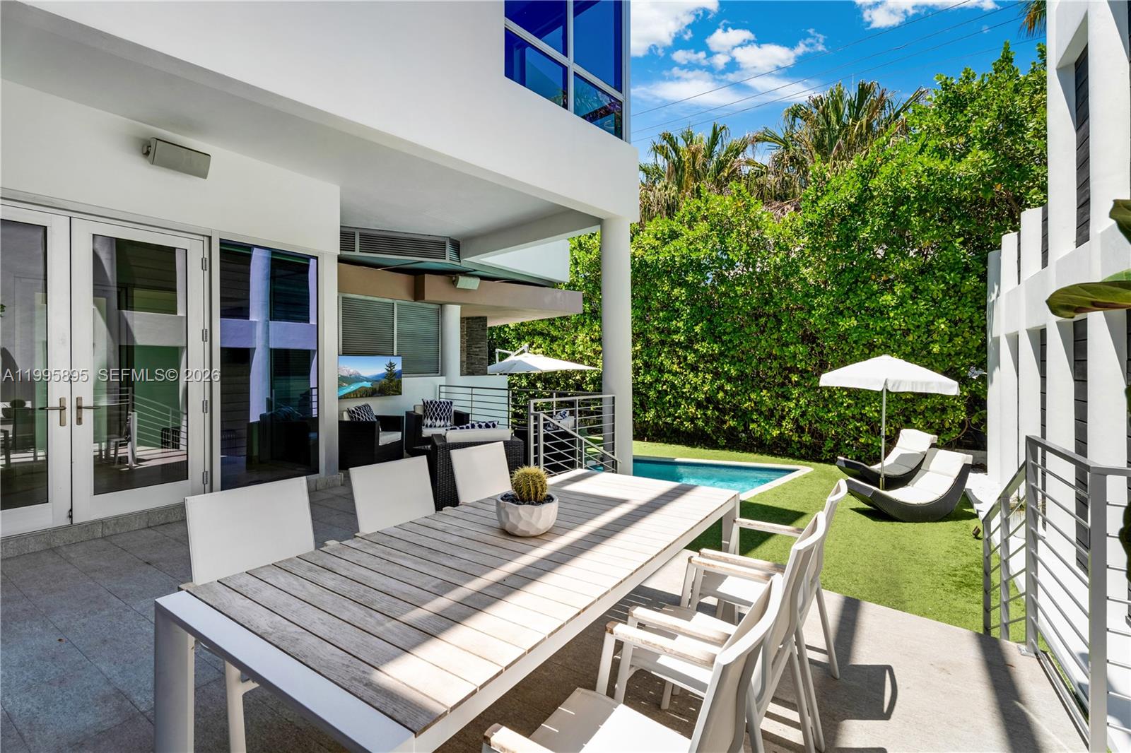 548 Fernwood Road, Unit 548 Key Biscayne, FL 33149 - Photo 31 of 50 a view of a patio with table and chairs potted plants and floor to ceiling window