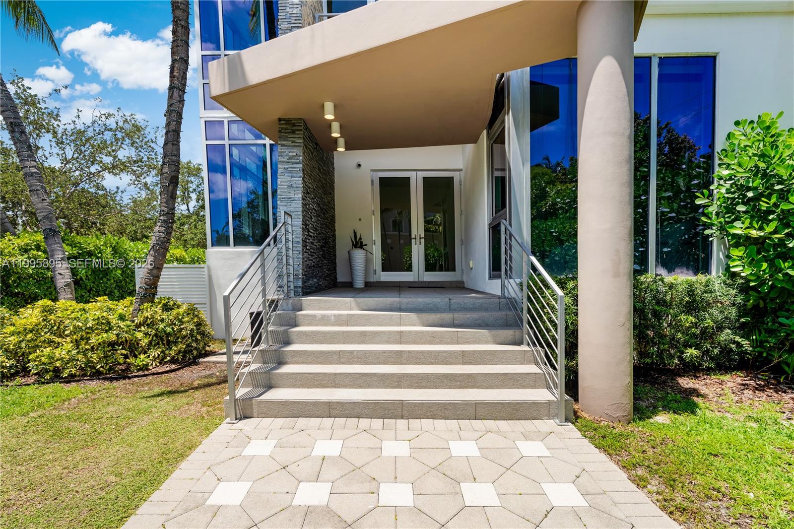 548 Fernwood Road, Unit 548 Key Biscayne, FL 33149 - Photo 41 of 50 a view of a house with large windows and flower plants
