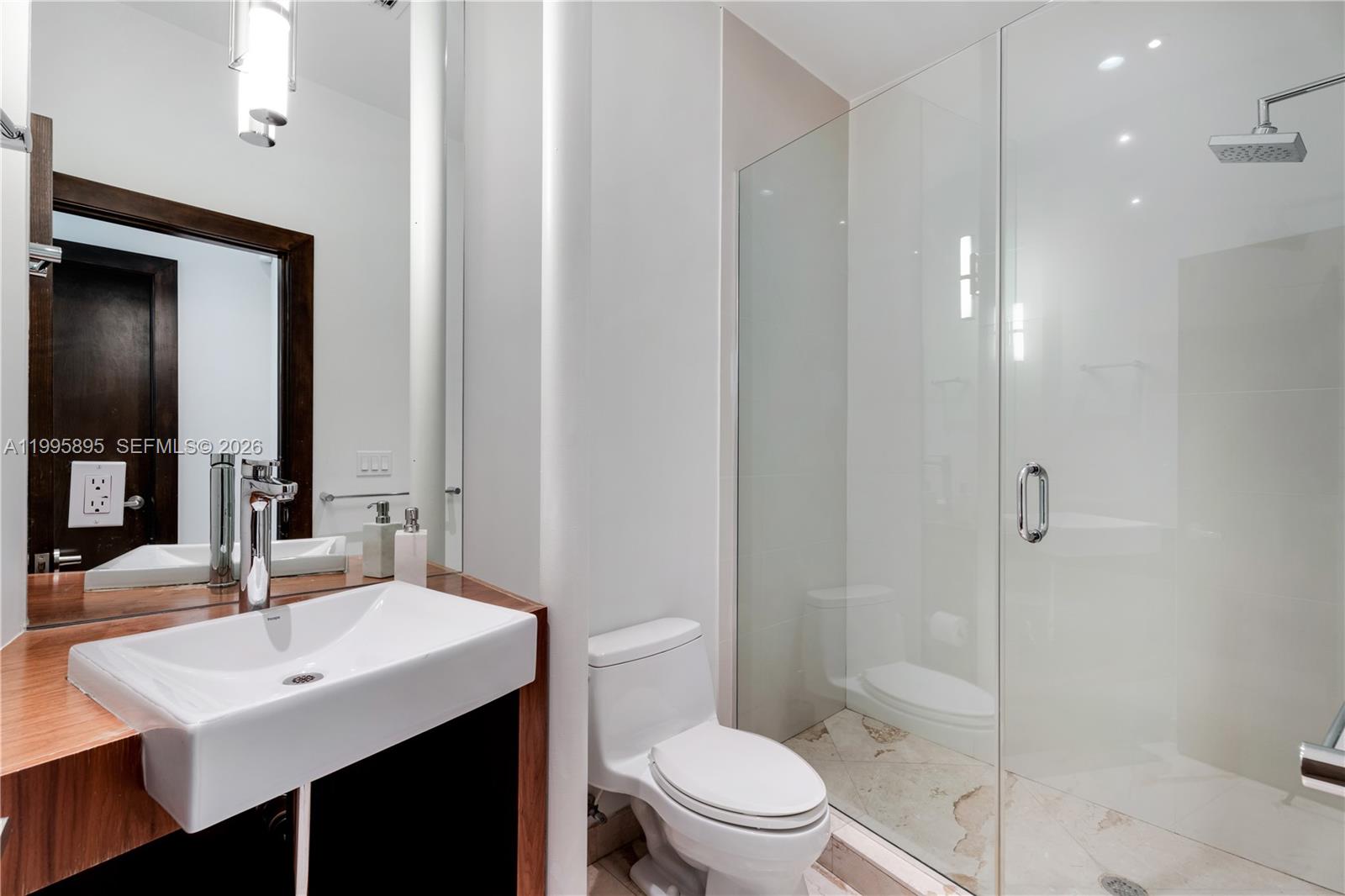 548 Fernwood Road, Unit 548 Key Biscayne, FL 33149 - Photo 8 of 50 a bathroom with a sink toilet vanity and shower