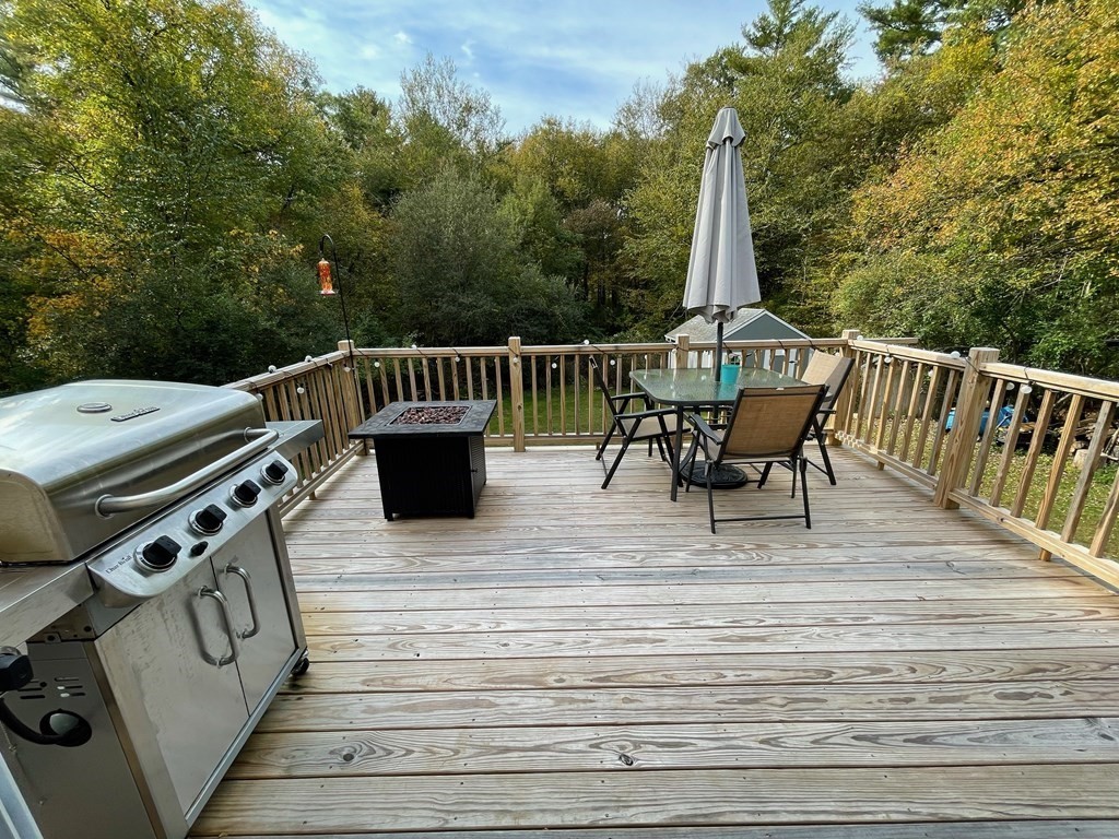 547 Delano Road Marion, MA 02738 - Photo 7 of 28 a view of a roof deck with table and chairs a barbeque with wooden floor and fence