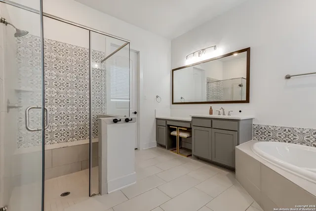 a bathroom with a double vanity sink mirror and shower