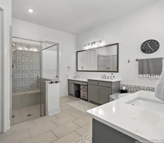 a spacious bathroom with a bathtub sink and mirror