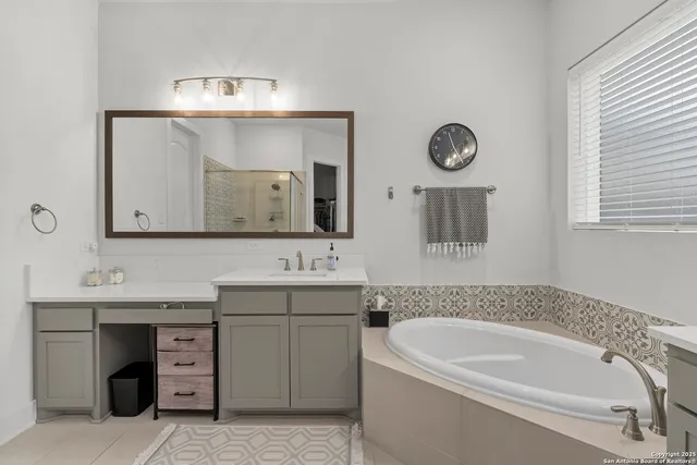 a bathroom with a bathtub a mirror and a sink