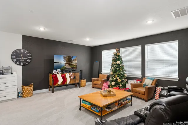 a living room with furniture a chandelier and a flat screen tv