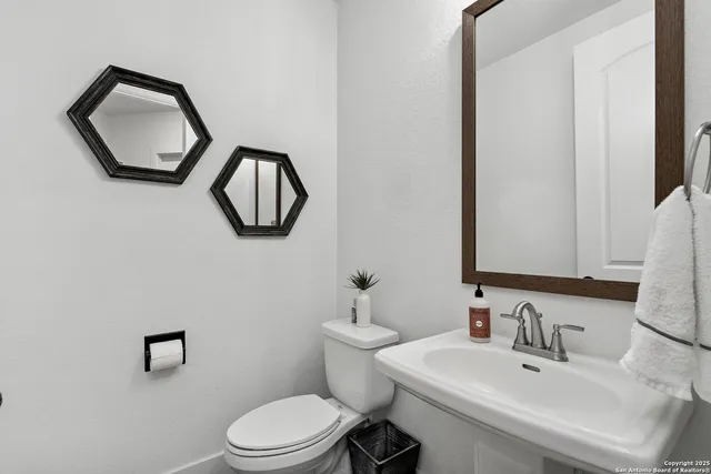 a bathroom with a toilet sink and mirror