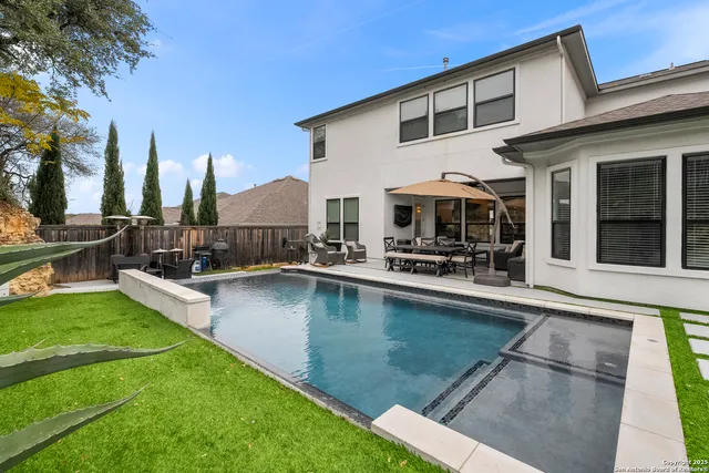 a view of a house with swimming pool and sitting area