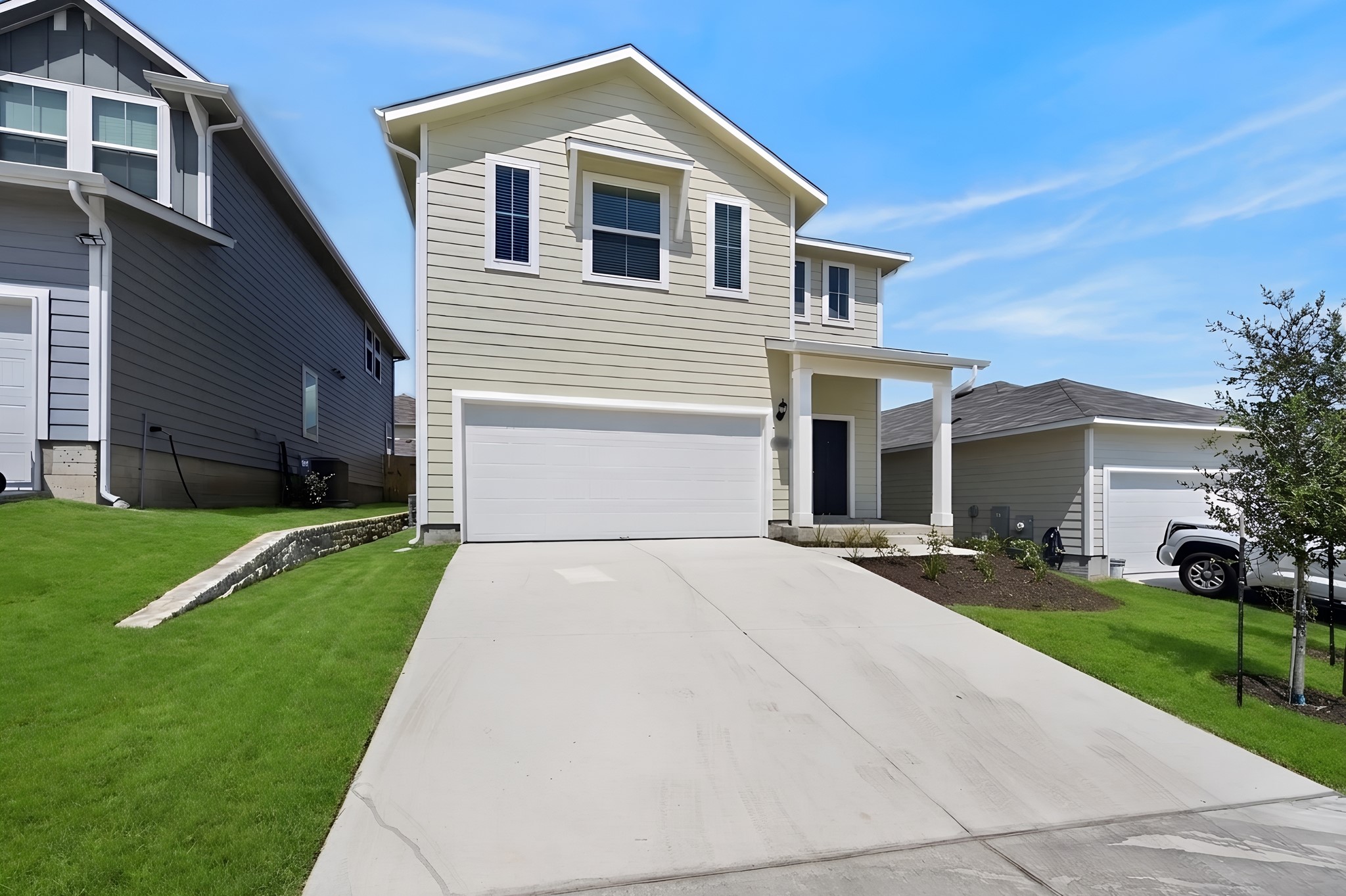 2704 Towy Road Manor, TX 78653 - Photo 35 of 36 A concrete driveway leads to a modern two-story home with a two-car garage.