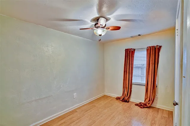 a view of a room with wooden floor and ceiling fan