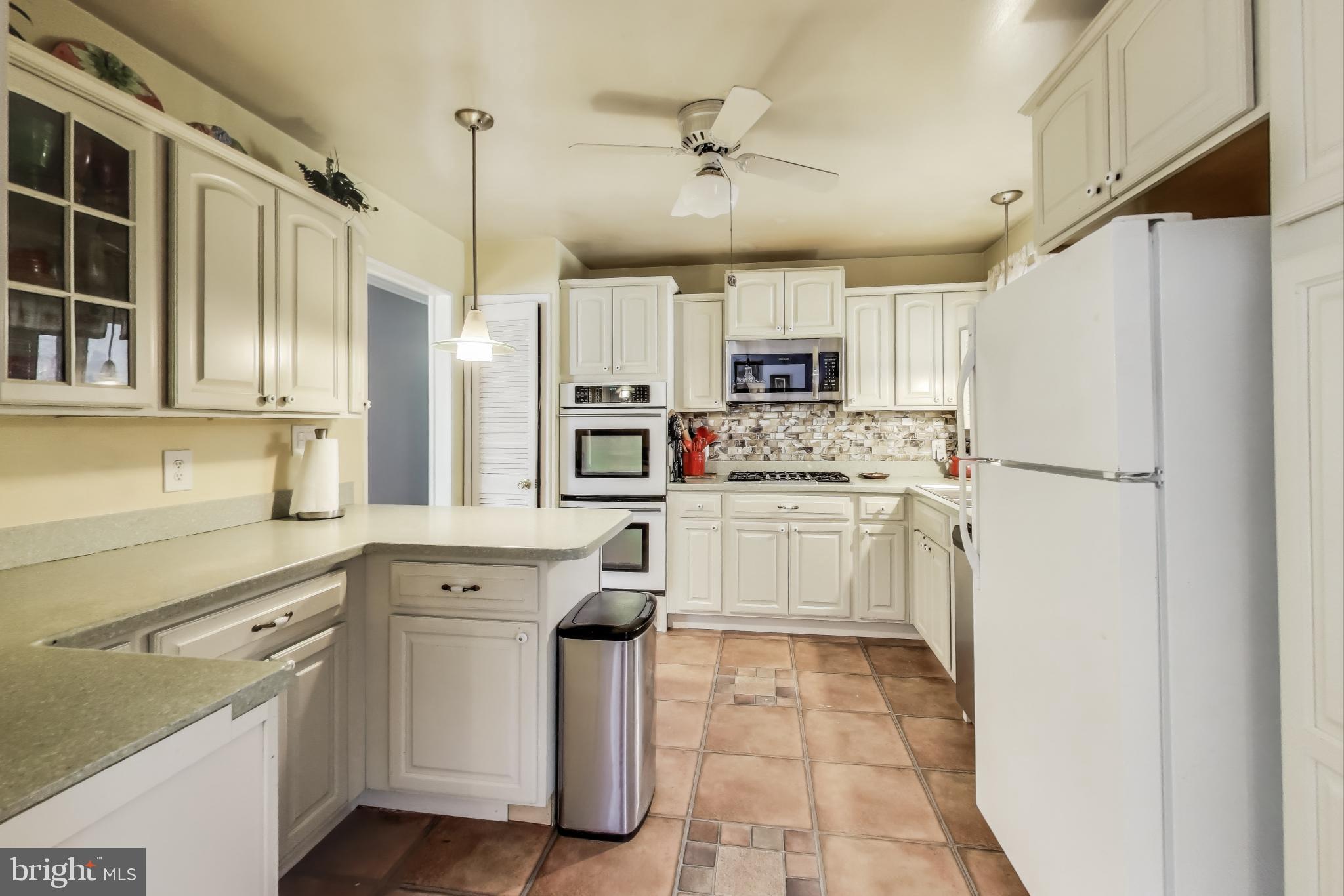 1804 Ironton Drive Oxon Hill, MD 20745 - Photo 6 of 37 a kitchen with kitchen island white cabinets stainless steel appliances and a sink