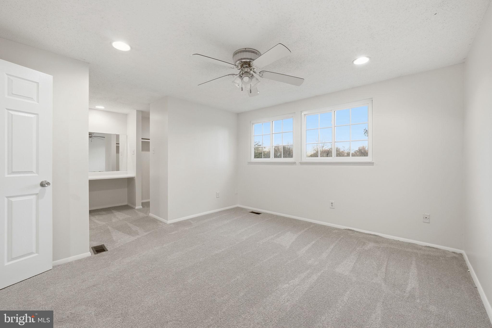 9804 Gabon Court Burke, VA 22015 - Photo 17 of 30 an empty room with a ceiling fan and windows