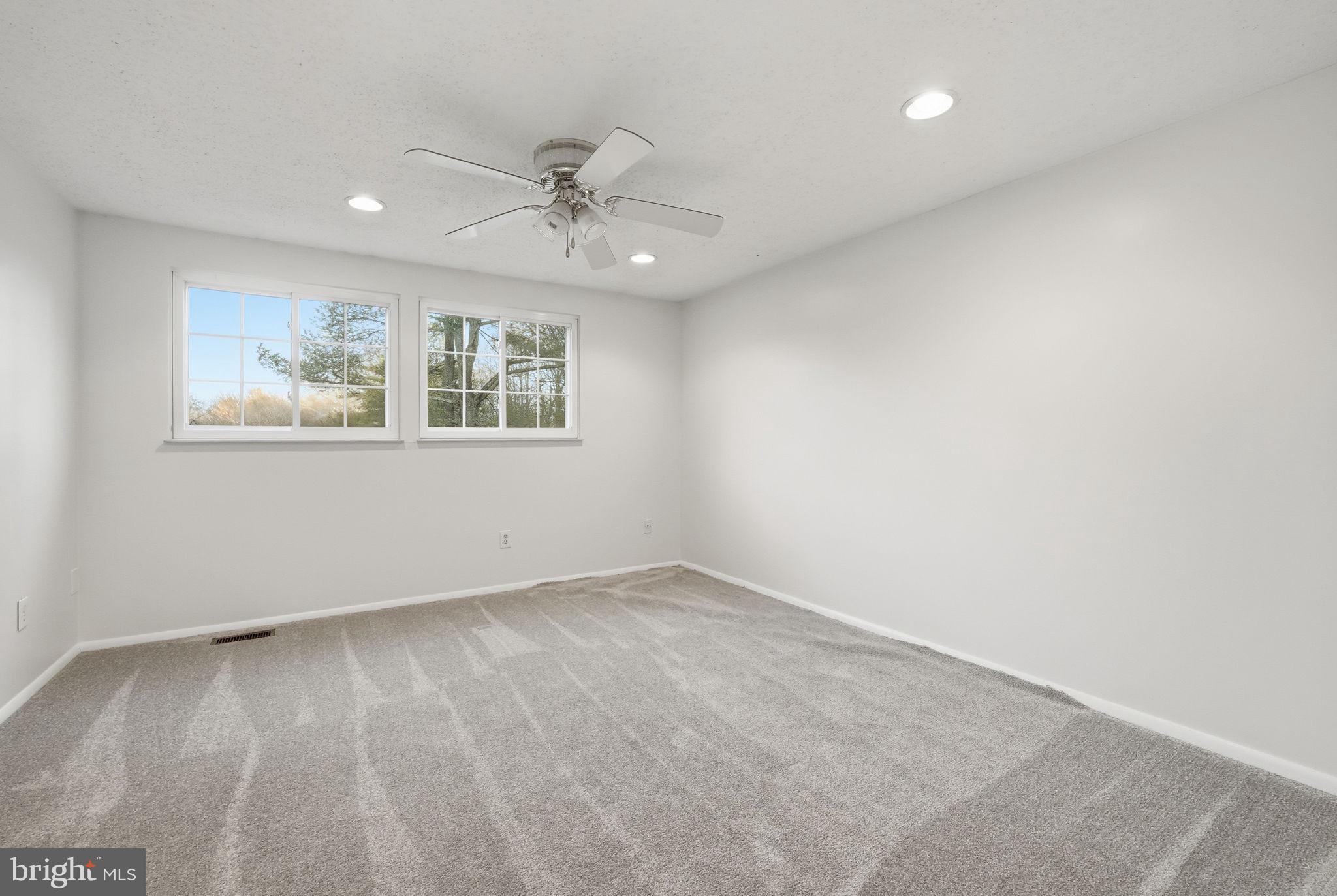 9804 Gabon Court Burke, VA 22015 - Photo 5 of 30 an empty room with wooden floor ceiling fan and windows