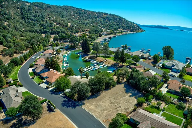 an aerial view of a house with a yard and lake view