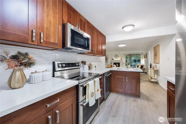 a kitchen with stainless steel appliances granite countertop a sink a stove top oven a counter space and cabinets