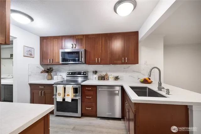 a kitchen with stainless steel appliances granite countertop a sink stove and refrigerator
