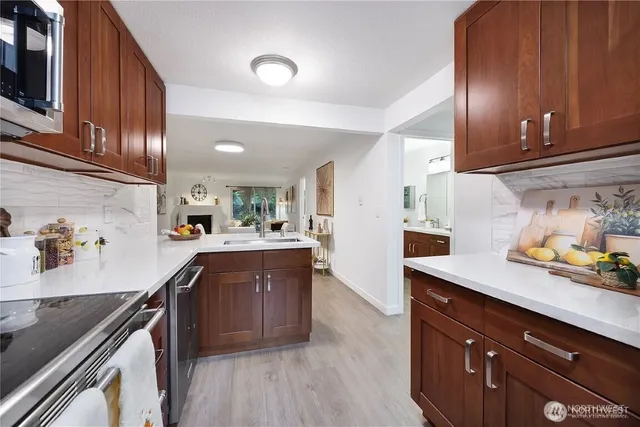 a kitchen with stainless steel appliances granite countertop a sink stove and wooden cabinets