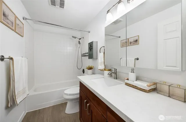 a bathroom with a double vanity sink toilet and shower
