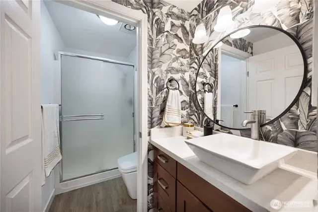 a bathroom with a sink a toilet and shower