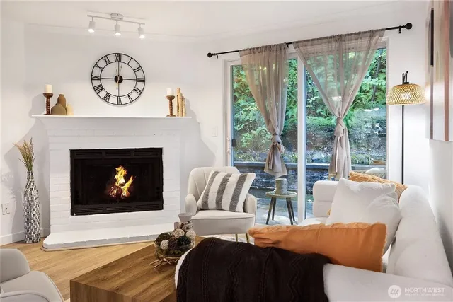 a living room with furniture a fireplace and a floor to ceiling window