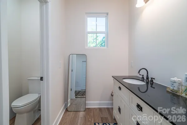 a bathroom with a granite countertop sink toilet and shower curtains