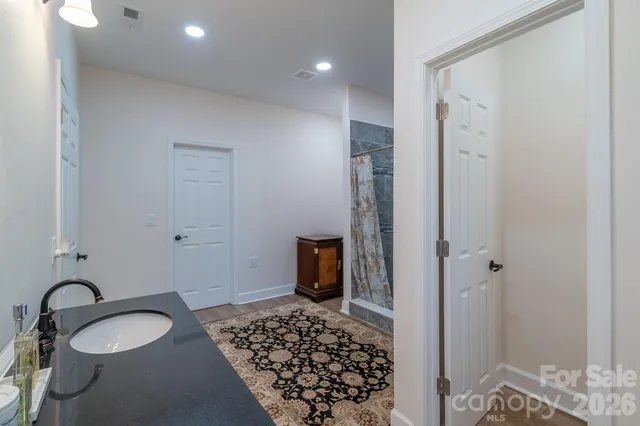 a bathroom with a granite countertop sink and a mirror