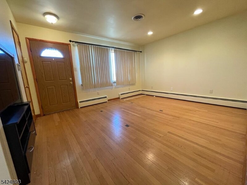 405 Redcliffe Street Elizabeth Port, NJ 07206 - Photo 2 of 10 an empty room with wooden floor and a window