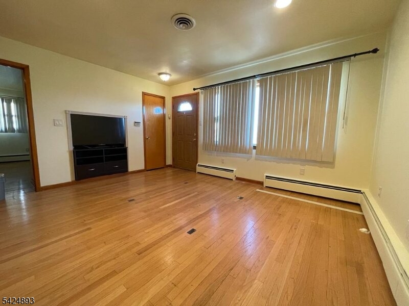 405 Redcliffe Street Elizabeth Port, NJ 07206 - Photo 3 of 10 a view of an empty room with wooden floor and a window