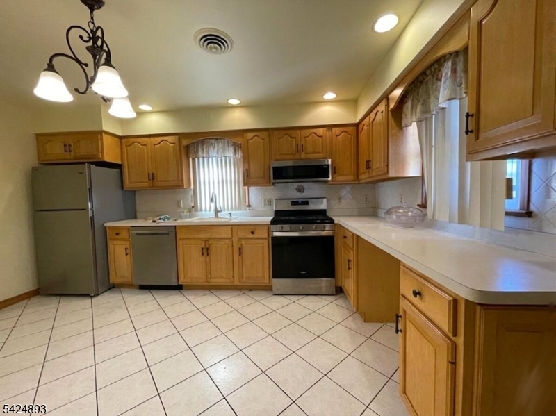 405 Redcliffe Street Elizabeth Port, NJ 07206 - Photo 5 of 10 a kitchen with stainless steel appliances a sink a stove a refrigerator cabinets and a sink