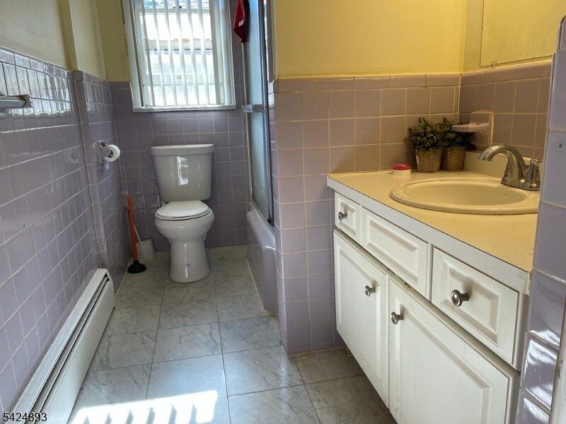 405 Redcliffe Street Elizabeth Port, NJ 07206 - Photo 7 of 10 a bathroom with a granite countertop sink a toilet and a mirror