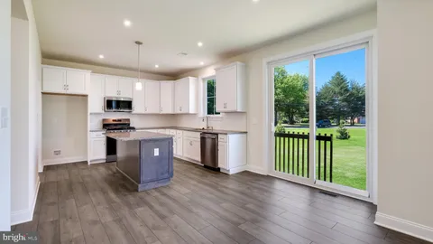 a kitchen with granite countertop a sink a counter space appliances and cabinets