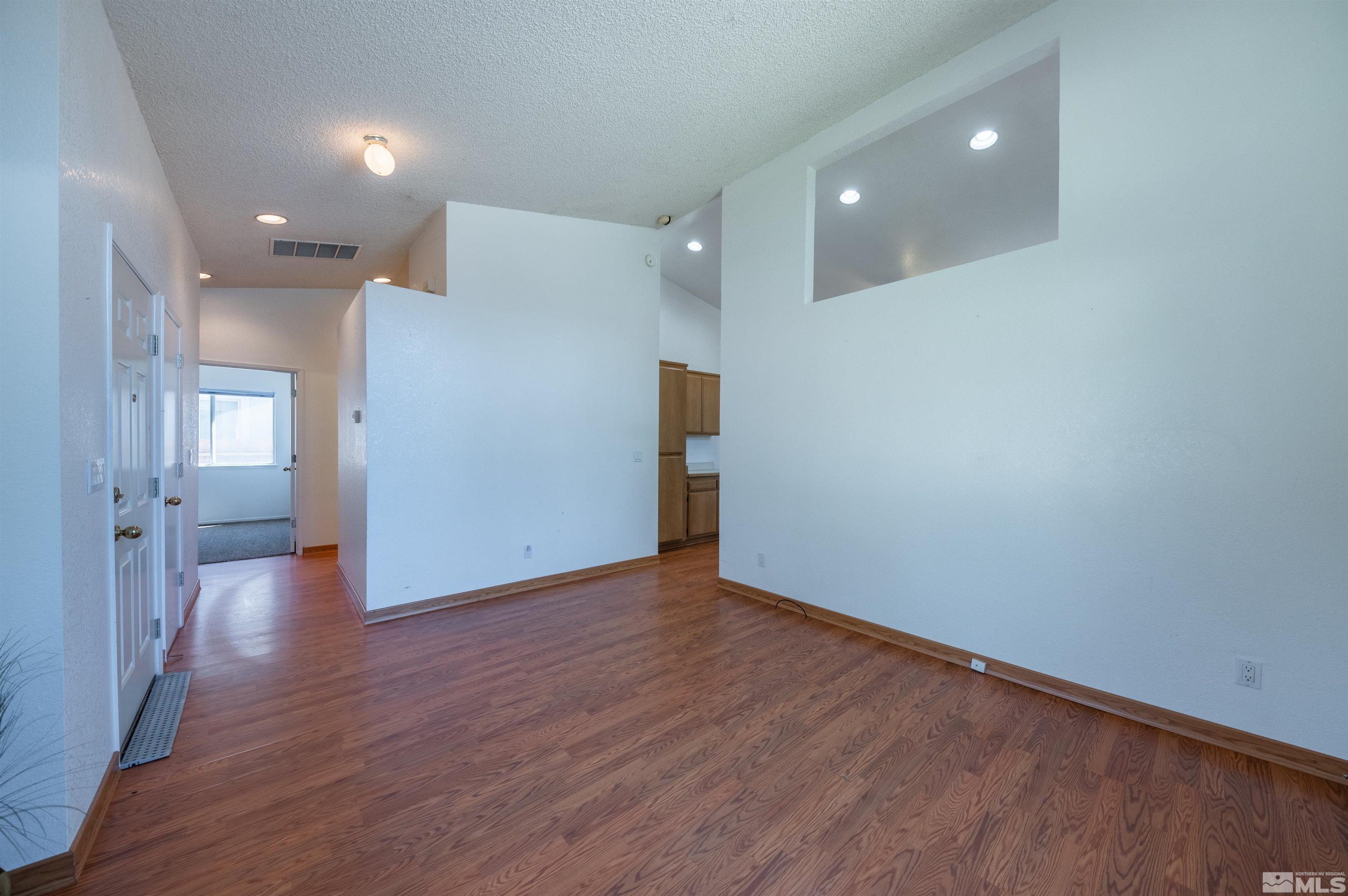 7675 Pickering Circle Reno, NV 89511 - Photo 8 of 28 a view of an empty room with wooden floor and windows