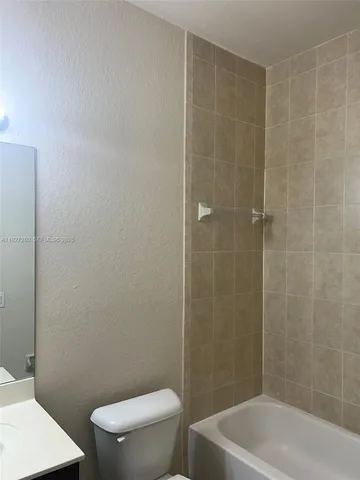 a white toilet sitting next to a bath tub