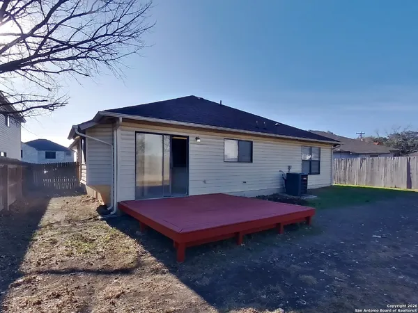 a view of a house with backyard and wooden fence