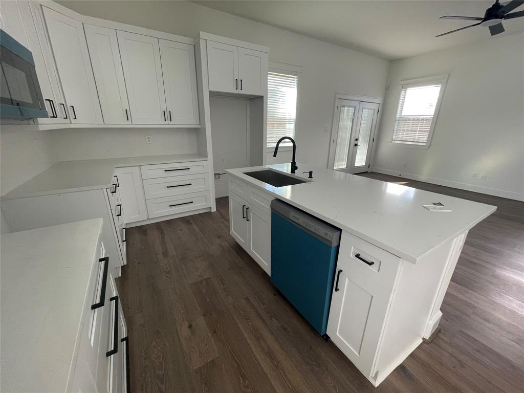 3535 Spring Avenue Dallas, TX 75210 - Photo 5 of 19 Kitchen featuring a center island with sink, dark wood-type flooring, white cabinetry, dishwashing machine, and light stone counters