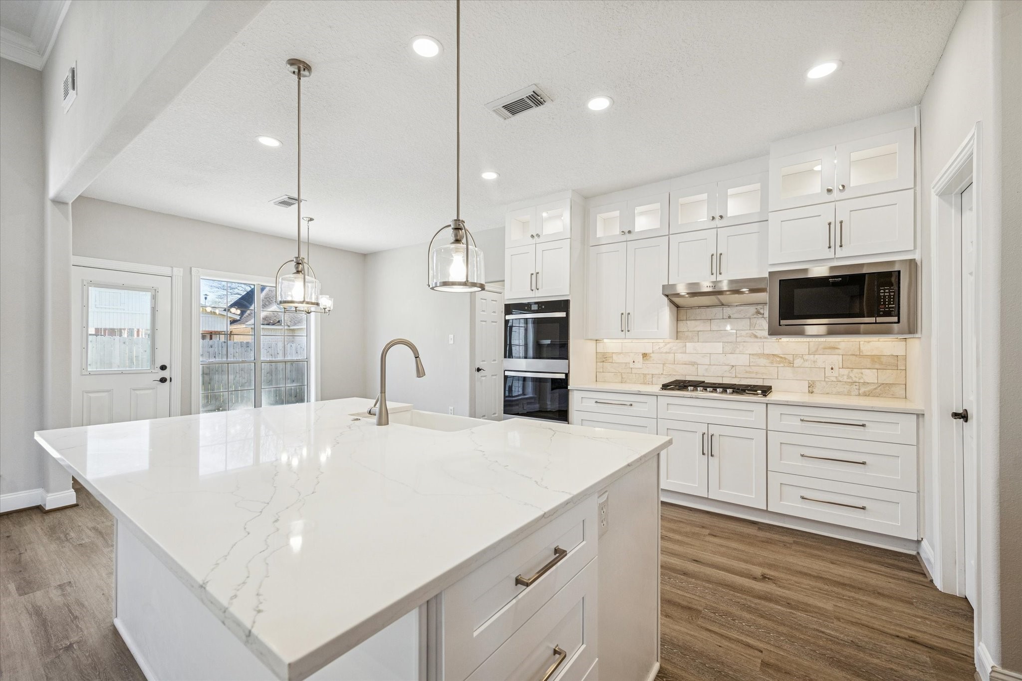 5437 Edgewater Court Willis, TX 77318 - Photo 9 of 29 a large kitchen with stainless steel appliances kitchen island granite countertop a stove a sink a oven and a refrigerator with wooden floor