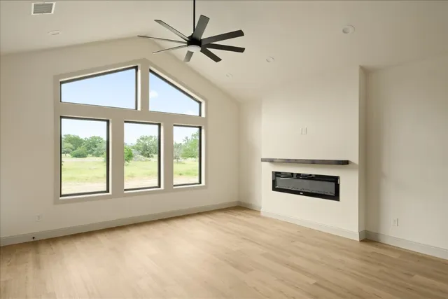 an empty room with windows and fireplace