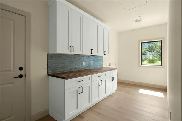 a kitchen with granite countertop white cabinets and sink