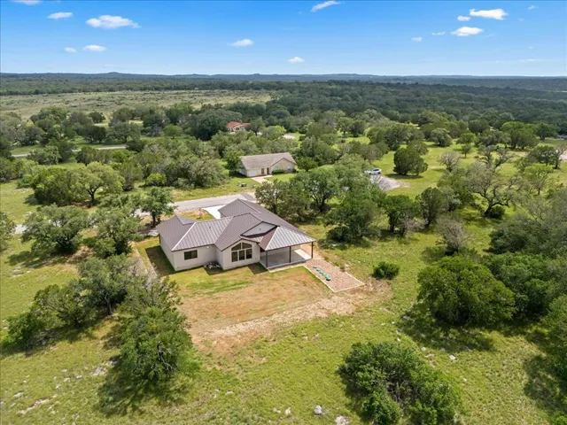 an aerial view of residential houses with outdoor space and trees