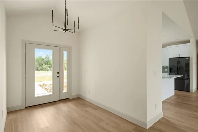 a view of empty room with wooden floor and window