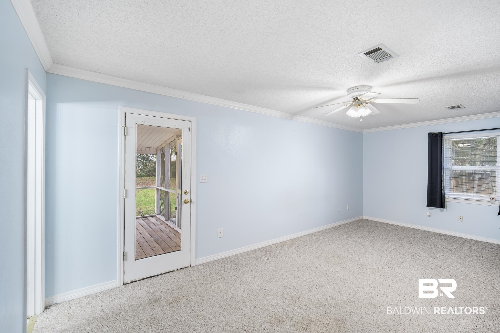103 Ann Street Daphne, AL 36527 - Photo 11 of 23 Carpeted spare room featuring crown molding, a textured ceiling, and a ceiling fan