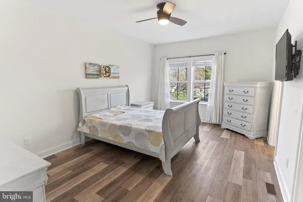 a bedroom with a bed and a flat tv screen on dresser