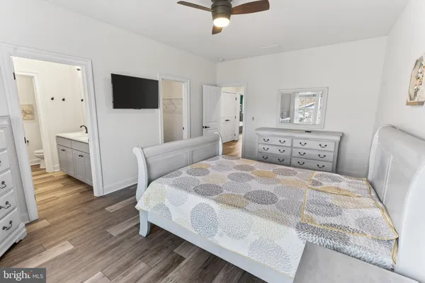 a spacious bedroom with a bed and a flat screen tv